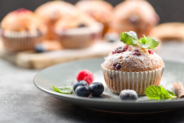 Freshly baked muffins with powdered sugar and fresh berries
