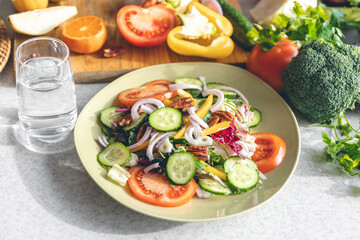 Fresh vegetable salad on the kitchen table in a plate close-up.