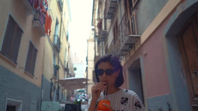 Beautiful young female in Italy drinking Aperol spritz