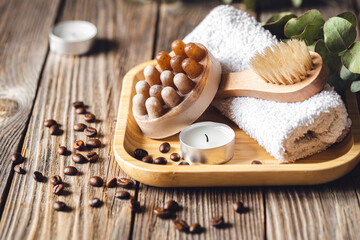 Spa composition with coffee massage scrub soap on a wooden surface.