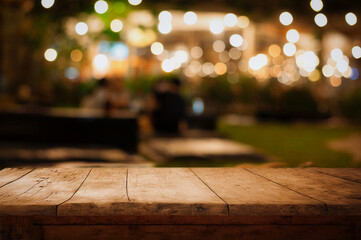 Empty wood table top and blur of cafe restaurant in dark night background