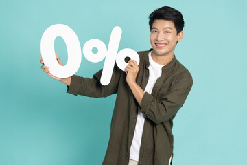 Portrait of Asian man showing and holding 0% number or zero percent isolated over light green background - obrazy, fototapety, plakaty