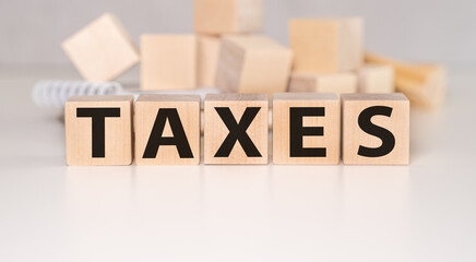 Taxes text on wooden cubes and tax payments and credit concept