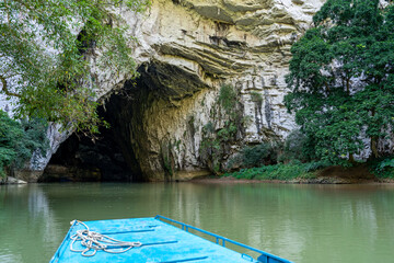 Vietnam, Boat tour in the Ba Be National Park. A boat aproches the entrance of the Puong Cave.