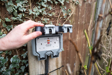 Homeowner showing a fully opened, double gang electrical socket and combined circuit breaker. Note...