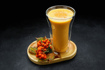 Pumpkin smoothie in a glass, on a dark background