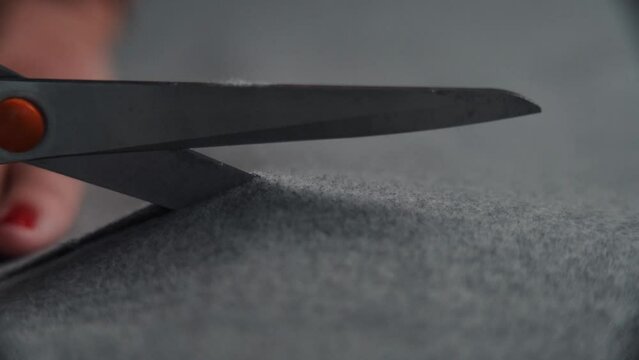 Female using scissors and cutting material fabric pieces