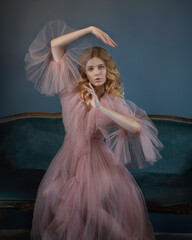 Portrait of a blonde woman in a light pink peignoir with puffy sleeves