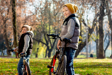 funny boy in the autumn park on bicycles