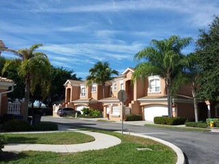 Fototapeta na wymiar Beautiful home of classical American architecture in Florida, surrounded by palm trees and greenery on a bright sunny day