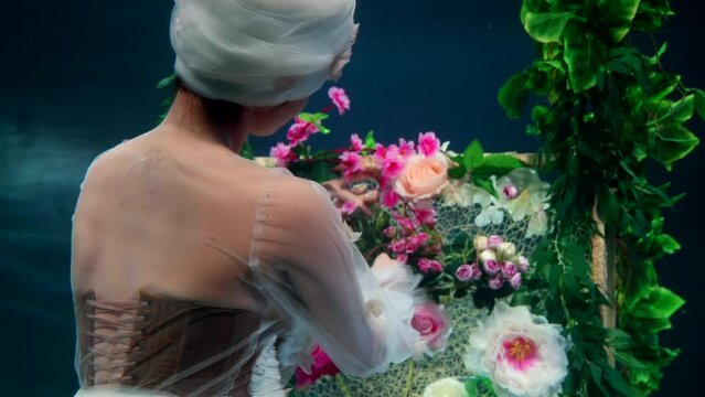 the mermaid seamstress creates her masterpiece underwater as a fairy tale character sews a carpet with flowers with threads