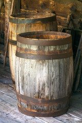 Old wooden barrels with iron rims for food storage.