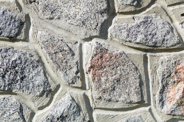 Textured background of natural stone wall. The stone wall is gray.