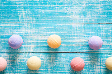 Multicolored bath bombs on a blue wooden background, top view.
