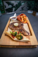 a glass of whiskey and a fresh steak with sauce