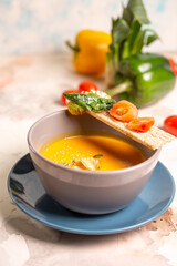 bright yellow pumpkin soup with seeds in a plate on the table