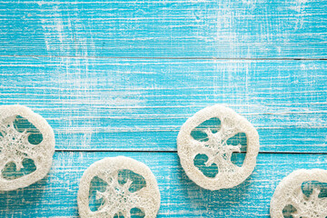 Natural loofah on a blue wooden background, top view. - obrazy, fototapety, plakaty