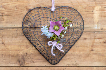 Herz mit kleinem Blumenstrauß mit Lenzrose und Puschkinia als florale romantische Dekoration