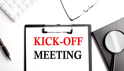 KICK-OFF MEETING text written on paper clipboard with office tools