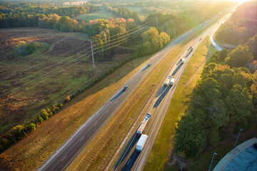 Aerial view of busy american freeway with fast moving cars and trucks. Interstate hauling of goods...