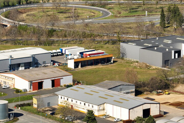 Fototapeta premium Aerial view of goods warehouses and logistics center in industrial city zone from above