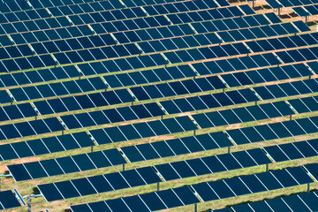 Aerial view of large sustainable electrical power plant with rows of solar photovoltaic panels for producing clean electric energy. Concept of renewable electricity with zero emission