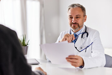 The male doctor reads a recommended therapy, sitting with the patient.