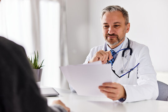 The Male Doctor Reads A Recommended Therapy, Sitting With The Patient.