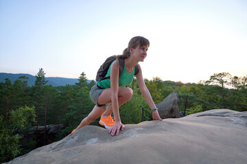 Young woman climbing alone on rocky mountain path. Female hiker enjoying difficult challenge on...