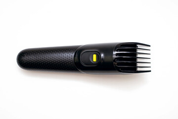 Razor trimmer for cutting and modeling hair lies on a white background. Electric shaver for barbershop. Accessory for shaving a beard or hair on a person's head