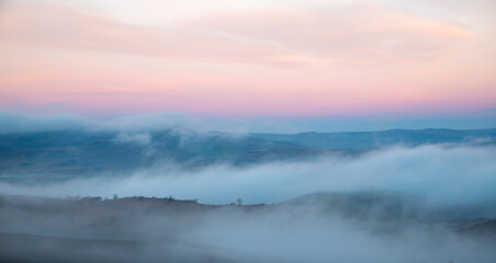 Landscape with fog between hills in  early morning