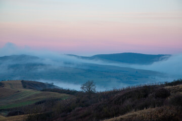Fototapeta na wymiar Morning fog between the hills in late autumn
