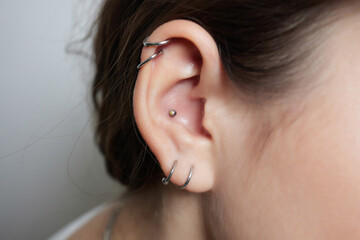 Stretched lobe piercing, grunge concept. Pierced woman ear with black plug tunnel. industrial and...