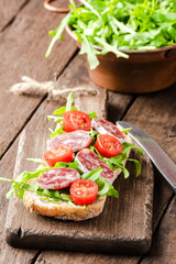 Sandwich with arugula on wooden board