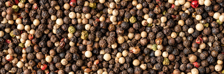 Mixed peppercorns texture. Background with copyspace. Close up. Top view