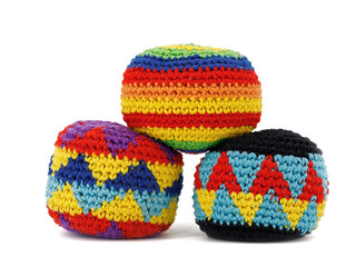three multicolored crocheted hacky sack balls isolated on a white background