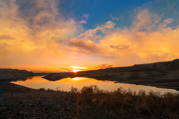 Beautiful sunset over the mountains and  lake. Panoramic sunset landscape.