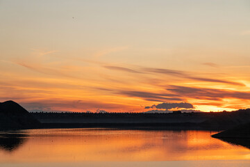 Fototapeta premium Beautiful sunset over the mountains and lake. Panoramic sunset landscape.