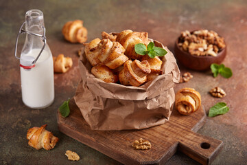 Mini croissant cookies with walnuts and brown sugar. Delicious homemade dessert served with milk.