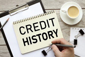 Credit History text on a black folder near a cup of coffee. light wooden background