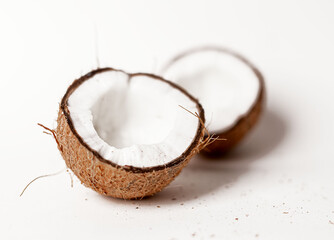 Open coconut halves. Two parts pieces of coco nut fruit with brown shell, ripe flesh