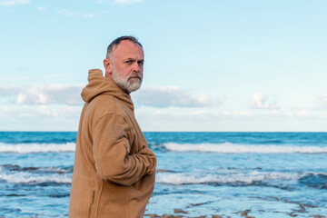 Bearded Man relaxing alone on the seaside on hot sunny day at sunset. Travel  Lifestyle concept
