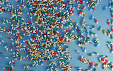 colorful pills fallen on the blue background