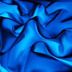 Black blue silk. Shiny fabric. Light. Glow. Liquid wave. Bright color. Background for design. Soft folds. Drapery.