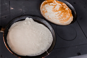 Many pancakes on the black serving plate. Preparing lunch
