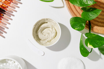 White bowl with white cosmetic clay on white background - bentonite facial mask. Skincare beauty...