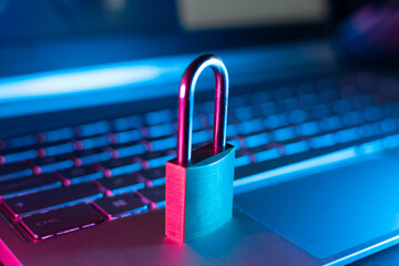 Cybersecurity and data privacy illustration with high-tech padlock protecting a laptop computer and...