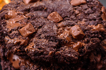 Delicious fresh oatmeal round cookies with chocolate on a black ceramic plate