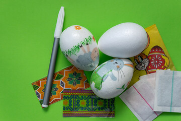 Easter eggs. Getting ready to paint Easter eggs. Colored paints and felt-tip pens. Green background.