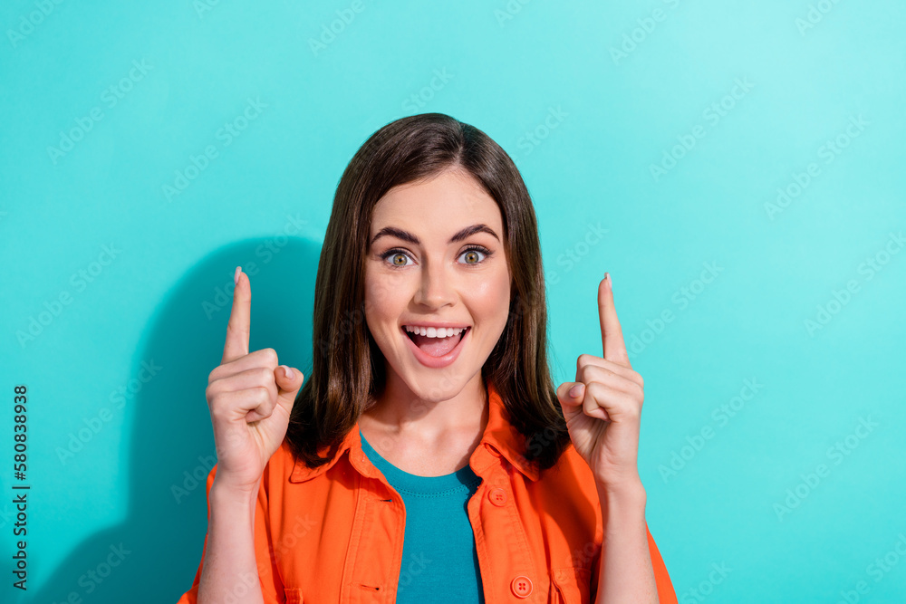 Poster close up photo of overjoyed funky girlfriend wear trendy orange clothes two arms demonstrate empty s